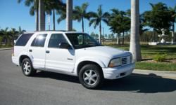 This is a 1999 Oldsmobile Bravada. It is white with tan leather interior and is clean inside and out. This SUV is an all wheel drive automatic with 106K miles and it runs and drives great. It features steering wheel controls, AM/FM/CD/Cassette audio,