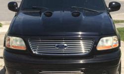 This 2002 Ford F150 has capable powertrains and suspension, responsive handling with an attractive and functional interior designs. Accented Stunningly in Tuxedo Black Metallic /Multi- Colored Ghost Flames on Hood, with Black Leather interior that brings