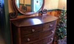 Vintage solid wood dresser with an elegant oval mirror.&nbsp; Very well made, great condition.&nbsp; Original antique silvered mirror, beveled.&nbsp; Dove tail joints.&nbsp; Claw foot legs in front.&nbsp; Glass pulls.&nbsp; Dresser&nbsp; measures 48"