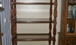 This is a wooden shelf unit with glass shelves and is in very good condition.