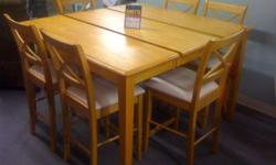 This is a nice counter height atble and 6 chairs in a light Honey colored solid wood table with x back bar stools to match. The size of this table is 36x54 and then it has a butterfly leaf that stores inthe table itself that expands this table to handle 8