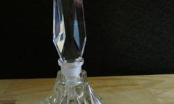 Beautiful crystal perfume bottle with very tall stopper in excellent condition. The base has a pretty cut glass style with a prism-like stopper. Marked HLI Lead Crystal, West Germany. This measures 6 1/2 inches tall and 2 3/4 inches wide.
