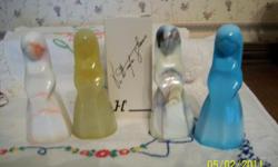 These collectible glass figurines, Jenny, was designed by Vi Hunter of Akron, Ohio and made by Mosser Glass Company in 1980. Each has the original box; 4 1/2" tall. The colors are Mandarin Slag, Golden Opaline, Cameo Bronze and Turquoise, all opaques. All