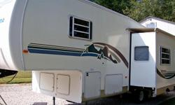 Year 2000. 28ft. Camper sleeps (6). Rear kitchen, full size Dometic refrigerator, samsung microwave, 3 burner range with oven and hood vent. Vinyl flooring kitchen area.
Living space: super slide - dining table and sofa sleeper. Ceiling fan, large tv