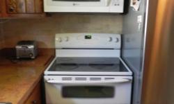 White Maytag Gemini Double Oven with smooth cooktop range
White Maytag Over the stove microwave with vent and lights