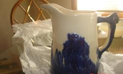 Sleepy eyed white&nbsp;and blue Indian Head pitcher appraised by DuMouchelles for $150.00.