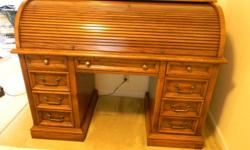 I have a beautiful traditional style solid oak roll top desk with brass hardware in mint condition. The overall outside dimensions are: 42.25"H x 53.5"W x 26.5"D. The desk is solid oak with a medium finish and boasts dovetail construction throughout. The