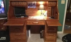 Large solid oak roll-top desk, excellent condition. Approx. 4'2" tall, 4'6" wide and 2"4" deep. Side drawers on lower right with shelf storage on lower left. Large work surface are with electrical cord access through corner. Two side pull outs with