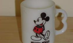 Vintage Mickey Mouse footed mug in fantastic condition. Looks like milk glass. Has sideways heart-shaped handle. Is stamped U.S.A. and 15 on the bottom. Looks like fire King, although it is not marked.