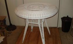 Lovely Victorian style white wicker table with glass.&nbsp; Weaved over a steel frame and very study, Very good condition. 30" round,
29 1/2" Tall.&nbsp; Cost $100.00 new.